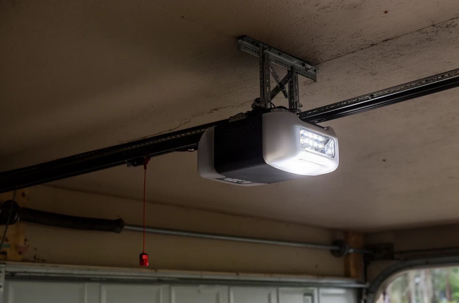 A ceiling-mounted garage door opener with rail and safety sensor